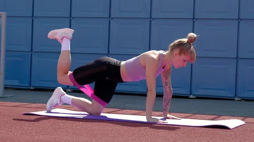 Young Woman Works Out with Resistance Band