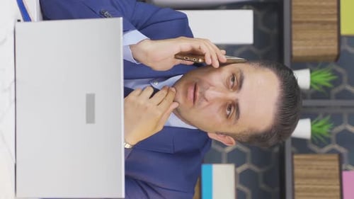 Vertical video of Businessman getting bad news on the phone.