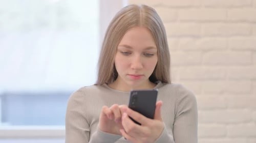 Woman Using Mobile Phone in Bright Room