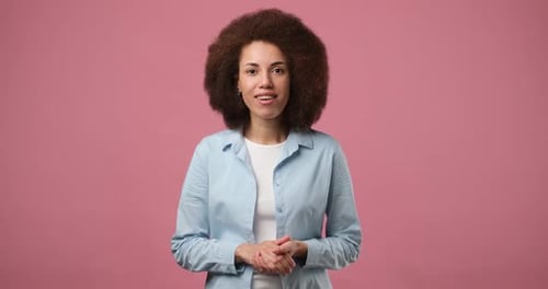 Smiling Attractive African American Woman Standing Over Pink Studio Background