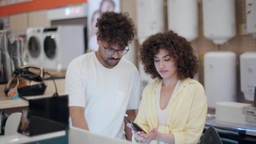 Customers choosing electric toothbrush in electronics store in slow motion