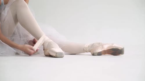 Elegant Ballerina Ties Pointe Shoes in Studio