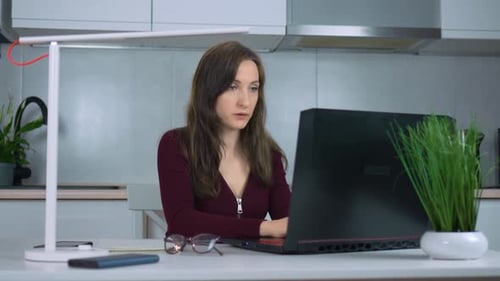 Businesswoman Using Laptop Types Away at Keyboard While Sitting at Home Office Desk Working Online