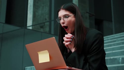 Young Woman Celebrating Business Success on Laptop