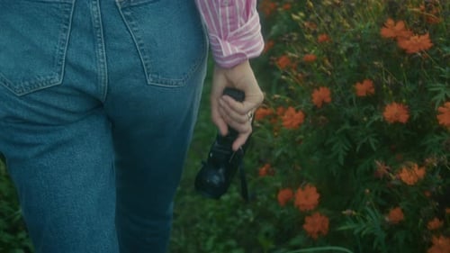 Woman Walking Through a Field with Camera