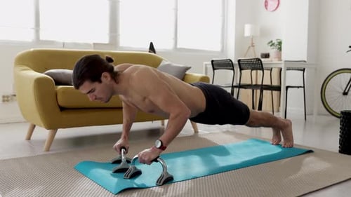 Shirtless Man Works Out with Push Up Bars at Home