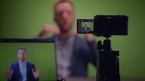 Professional Speaker Recording Session Conducted in Front of a Green Screen Setup