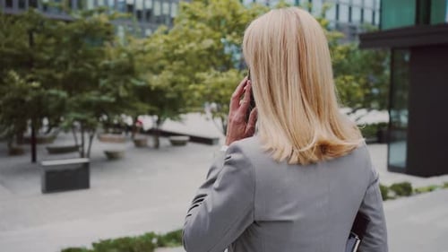 Businesswoman Talking on Phone Outside Office Building
