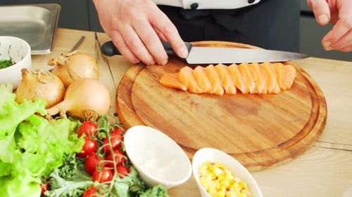 Chef Slicing Fresh Salmon in a Kitchen