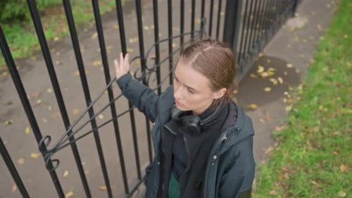 Woman Pauses Thoughtfully Female Individual Reflects Near Park Entrance Amid Autumn Leaves