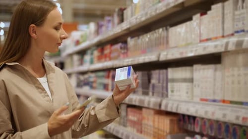 A Young Woman with Long Brown Hair Buys Personal Care Products in the Cosmetics Department of a