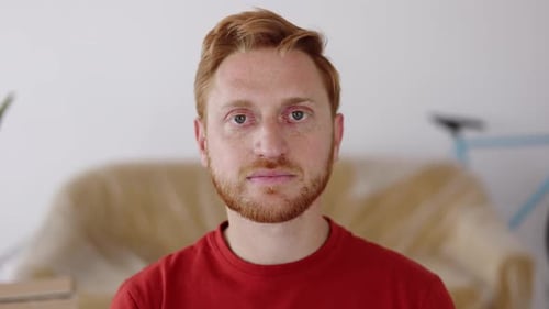 Portrait of Young Ginger Man Looking at Camera Standing at New Loft Apartment