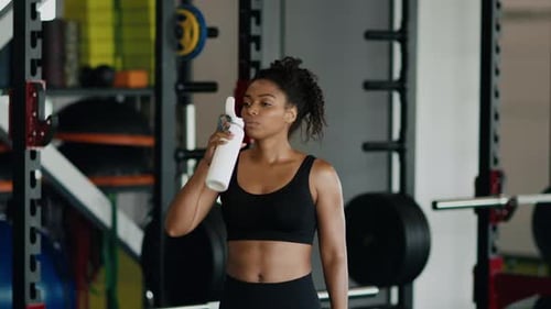 Woman Drinks Water After Intense Gym Workout