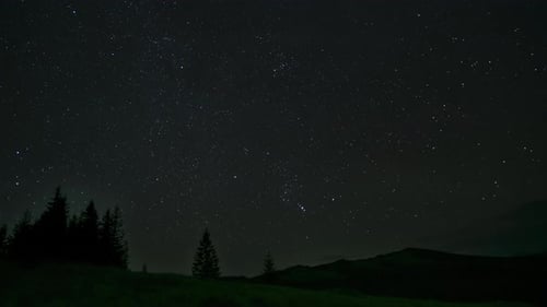 Zeitraffer bewegter Wolken und Sterne über den Bergen am Nachthimmel