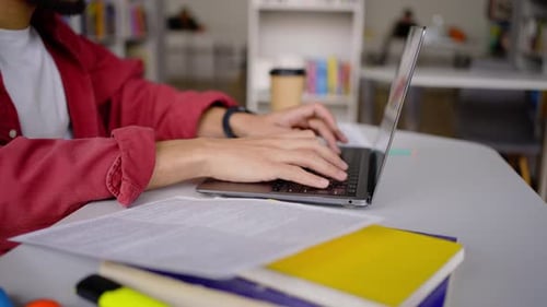 Détails Les mains d'un étudiant universitaire saisissent du texte sur le clavier d'un ordinateur portable sur le campus de la bibliothèque