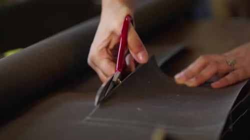 Corta a medida una tela dura con tijeras para hacer una bolsa 1