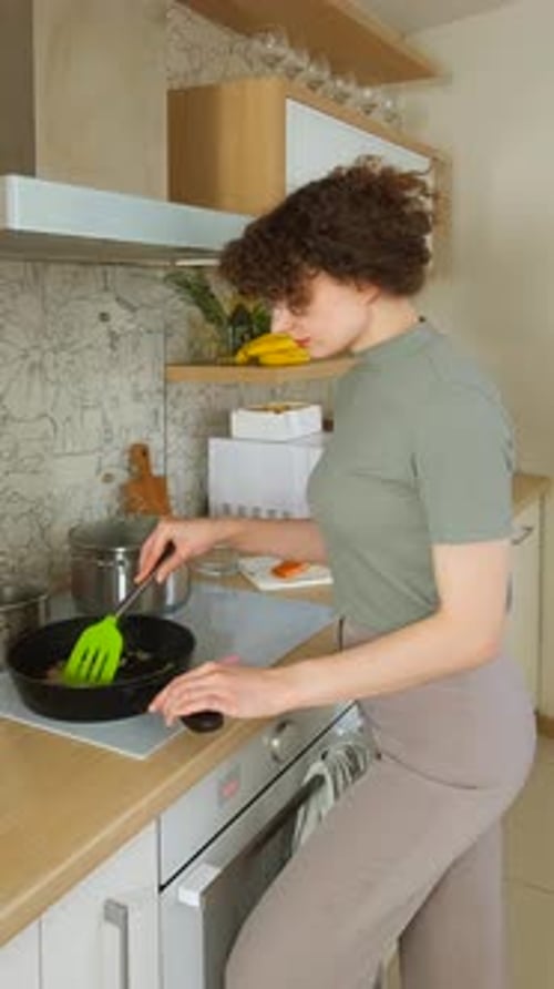 Woman Cooking Food in Kitchen at Home