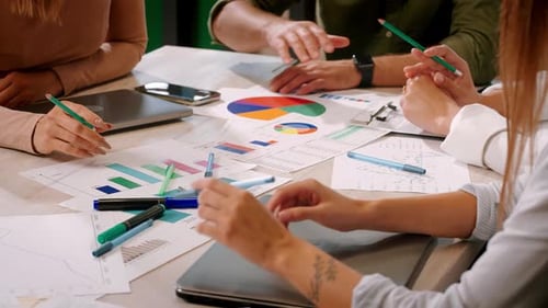 Group of Office Workers Discusses Documents Sitting at Table