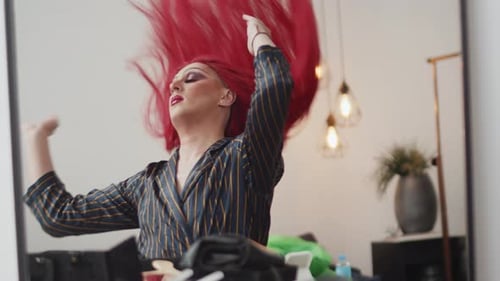 Person Adjusts Red Wig in Mirror