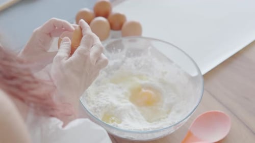 Eggs Being Added to Flour for Baking