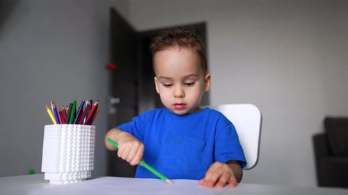 Der
schöne kleine Junge konzentriert sich auf das Zeichnen. Nettes Kind, das zu Hause Kunst macht. Nahaufnahme.