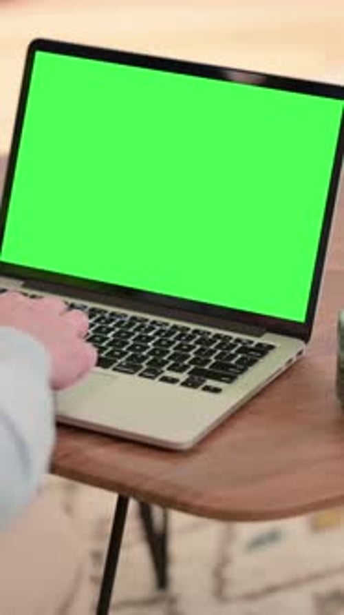 Man Working on Laptop with Green Chroma Screen, Vertical Video