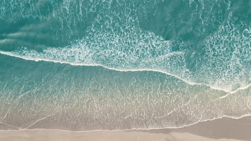 Drone aerial view of paradise beach. Turquoise sea water and clear sand at sunset.