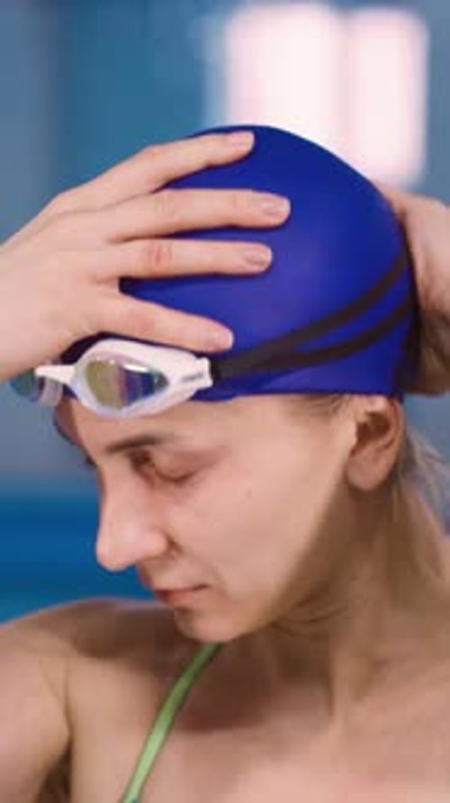 Retrato de uma jovem nadadora caucasiana se preparando para nadar na piscina Uma mulher é