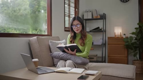 Woman wears green sweater working studying and liniving at home.