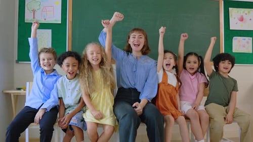 Portrait of diversity student sitting on chair with teacher at school.