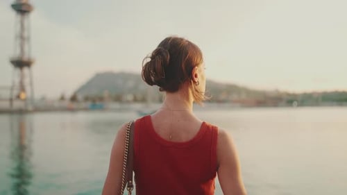 Close-up, girl stands on the seashore and looks at the bay