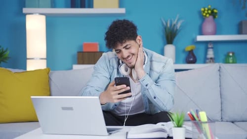 Smiling Young Adult Using Smartphone at Home