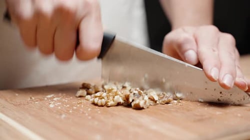 young woman chopping with a knife, walnut, Close-up.