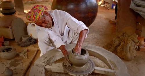 Potier indien au travail lançant un pot en argile façonnant un tour de potier dans un atelier de poterie du Rajasthan en Inde