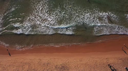 Aerial Drone Top Down View of Sea Blue Waves Break on Sand Beach