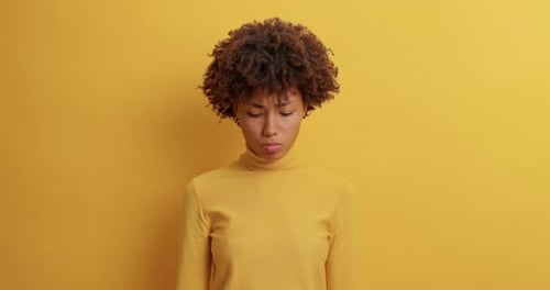 Disappointed Sad Woman Has Melancholic Look at Camera Purses Lips Being Offended