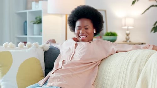 Woman Enjoying Music on Couch at Home