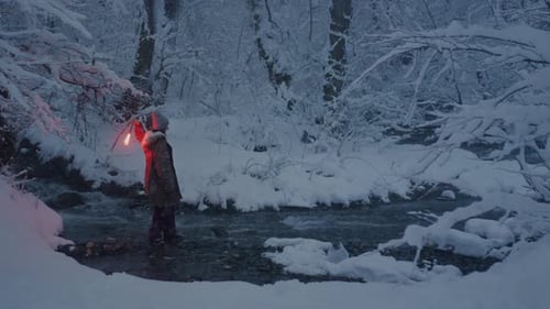 Young Girl Holding a Burning Signal Fire A Woman in a Winter Forest Starts a Red Rescue Flare