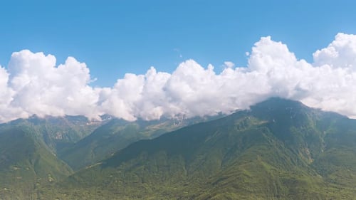 Majestic Mountain Range with Clouds and Blue Sky