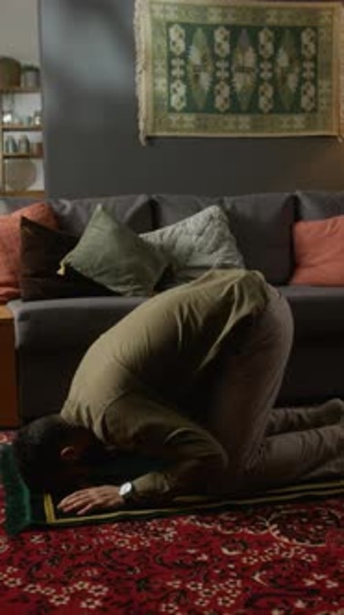 Man Kneeling and Praying on Traditional Prayer Rug