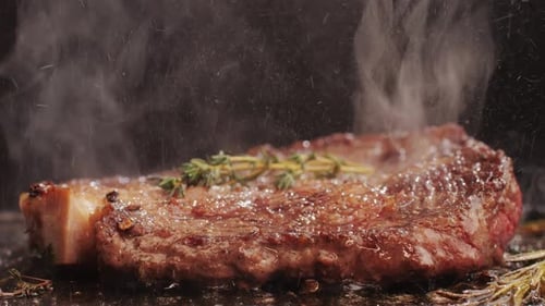 Fresh Marbled Beef with Pepper Salt and Rosemary Closeup Macro Cooking Juicy Steak on Grill with Oil
