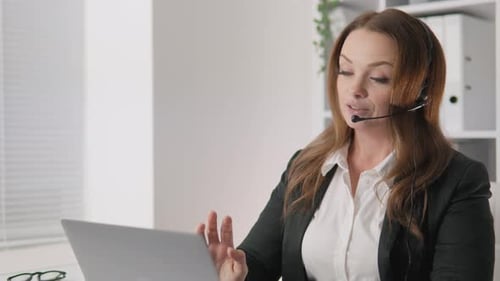 A Satisfied Female Call Center Operator Working Remotely Gives Customers a Smile and Excellent