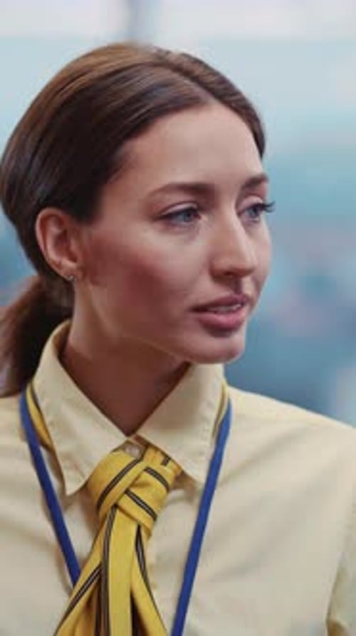 Une femme confiante vêtue d'une chemise jaune vif interagit avec la caméra