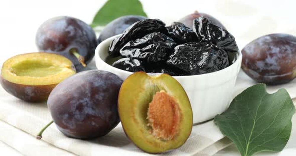 Woman taking tasty prunes at table, closeup, Food Stock Footage ft ...