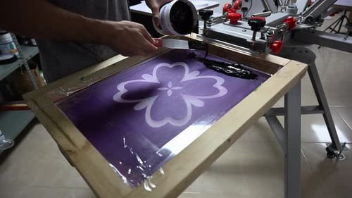 Man Applying Black Ink to Screen Printing Frame