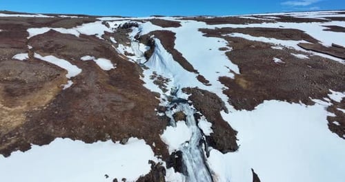 Aerial View of Waterfall in Snowy Landscape
