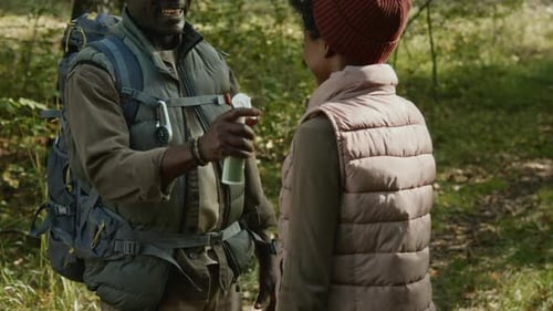 Man Sprays Bug Repellent on Child in Forest