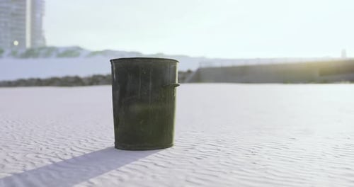 Trash Bin Stands Alone on a Clean Sandy Beach During Sunset in a Coastal City