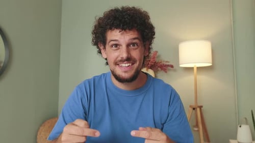 Man Talking and Gesturing Indoors at the Camera