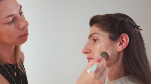 Makeup Artist Applying Foundation on Woman Model Face in Beauty Studio